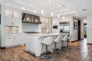 A modern kitchen with four bar counters and stools